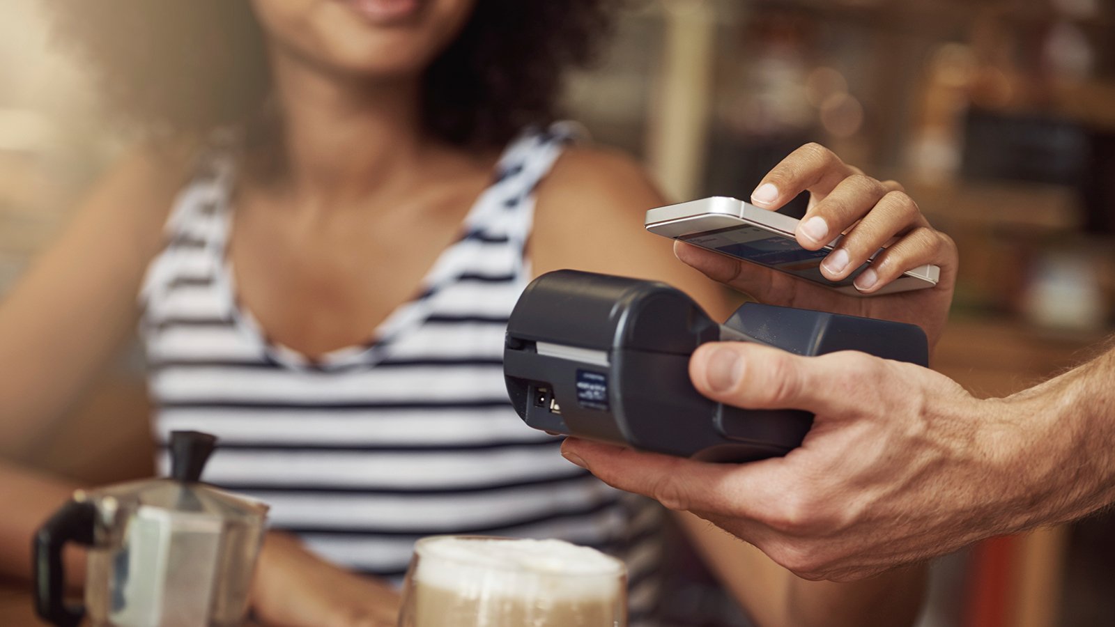 Customer using Visa payWave terminal to wave-pay for their coffee