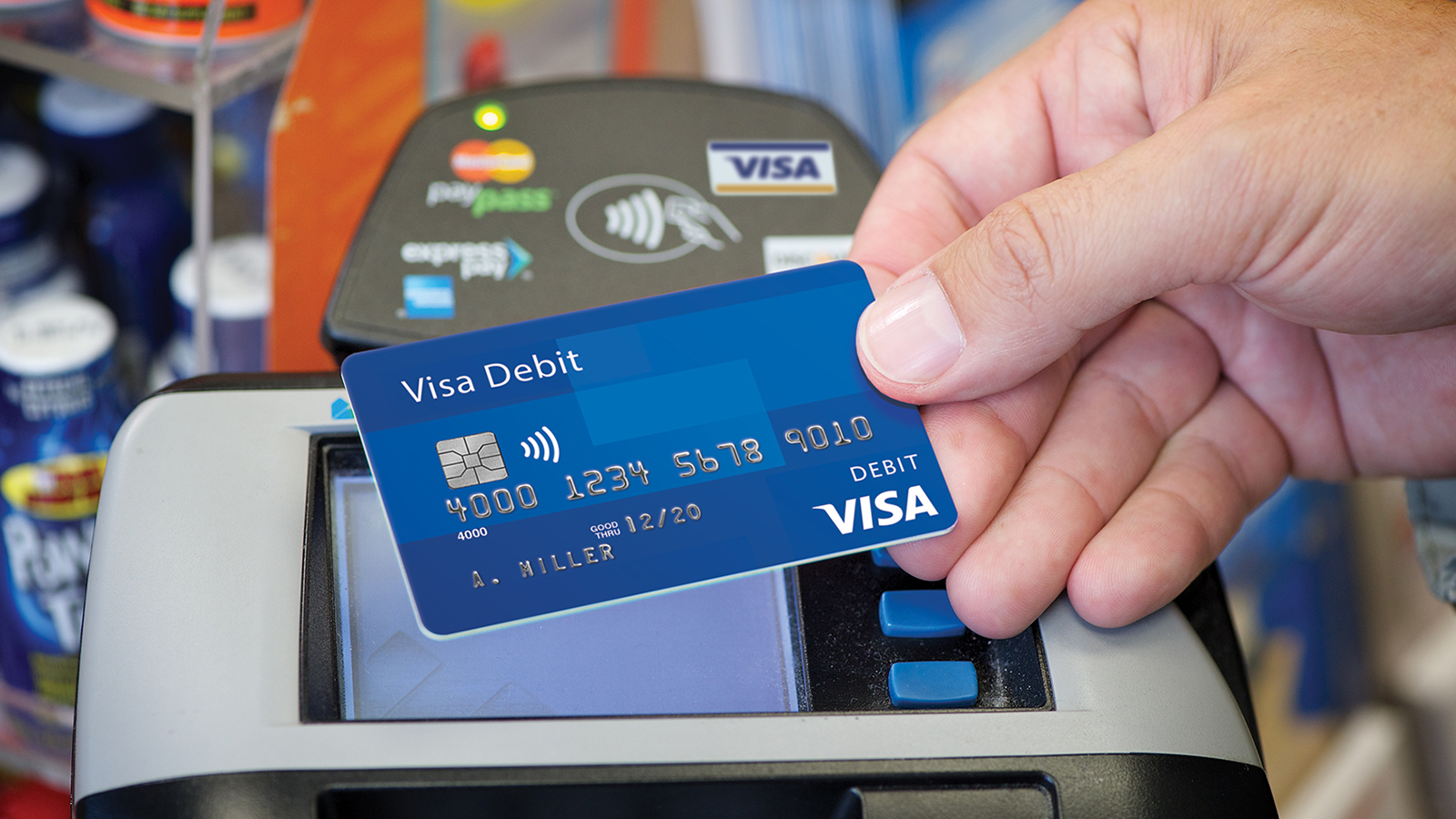 Person using a Visa payWave debit card at a payment terminal.