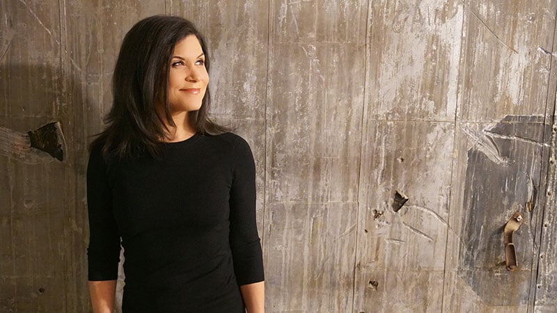 Girl Starter co-founder Dani Davis posing in front of a wooden accent wall.