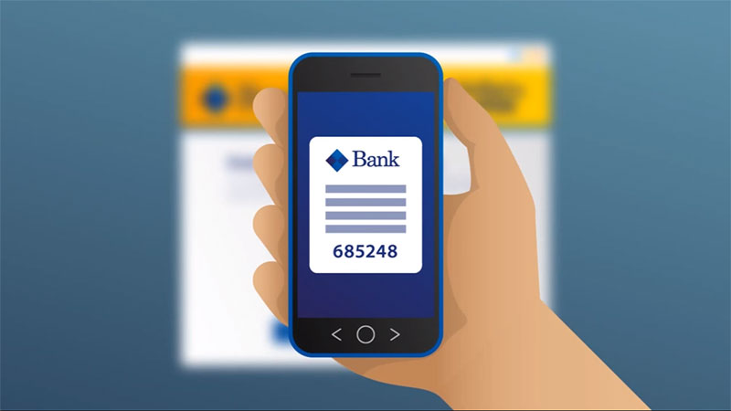 A hand holding a mobile phone with bank details on the screen, depicting the availability of secure online transactions with Visa.