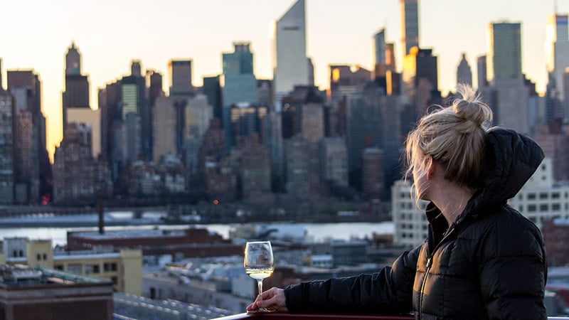 Girl drinking wine in New York City at sunset - rooftop bar